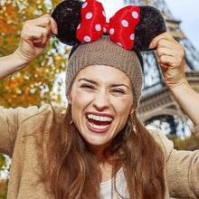Load image into Gallery viewer, A woman wearing red headband with polka dots and disney minnie mouse ears 
